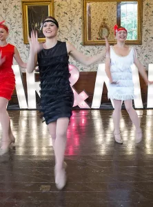 Ladies dressed in 20's flapper fashion dancing