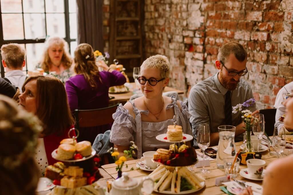 guests at a wedding seated at a table enjoying afternoon tea